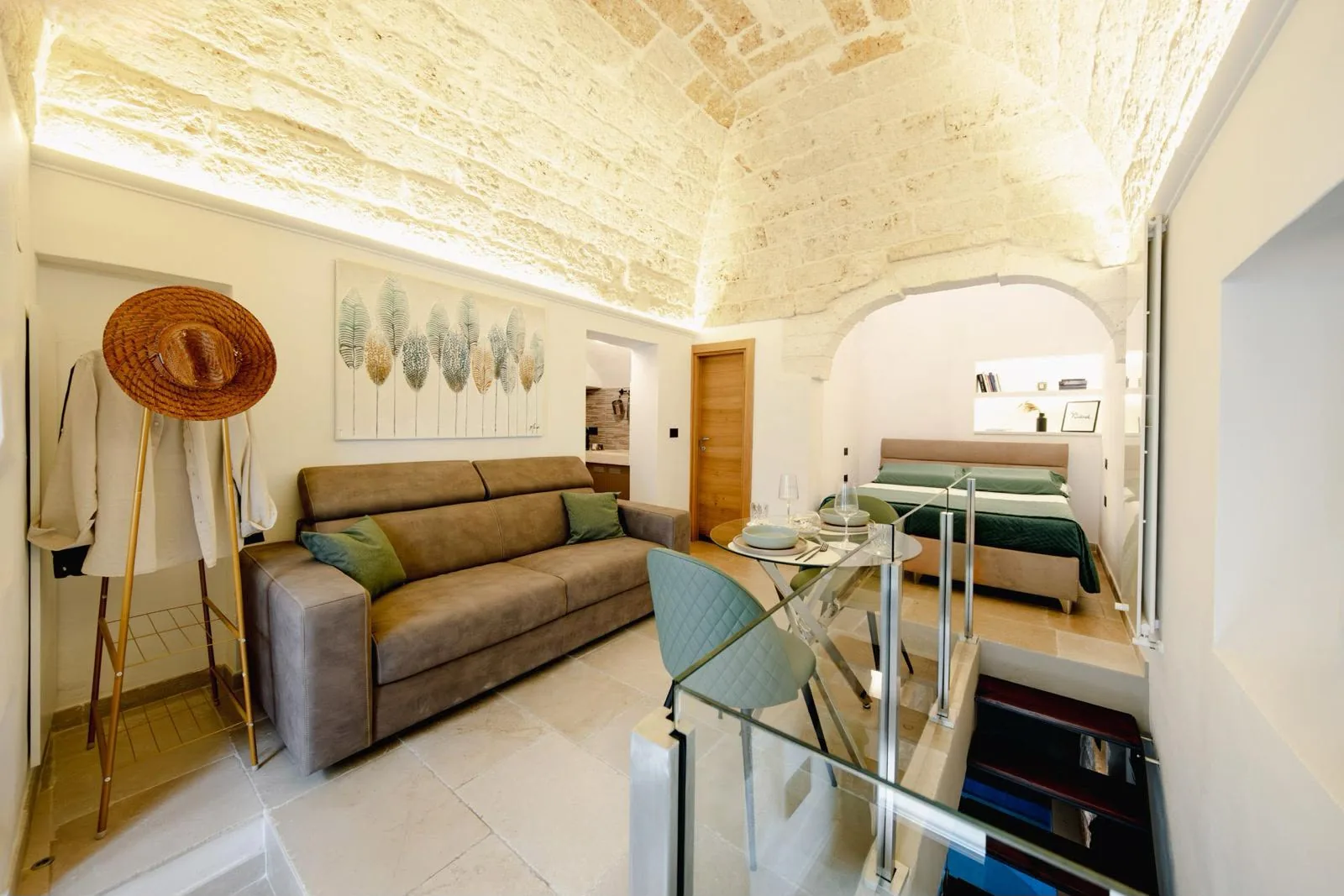 Zona giorno e letto sotto l'arco in pietra