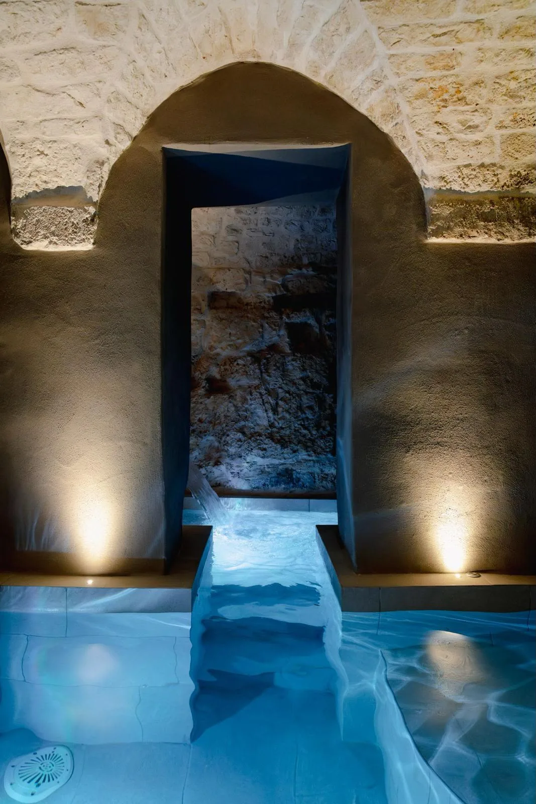 L'acqua azzurra della piscina sotto l'arco illuminato