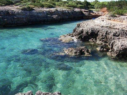 Caletta rocciosa con mare turchese vicino Ostuni