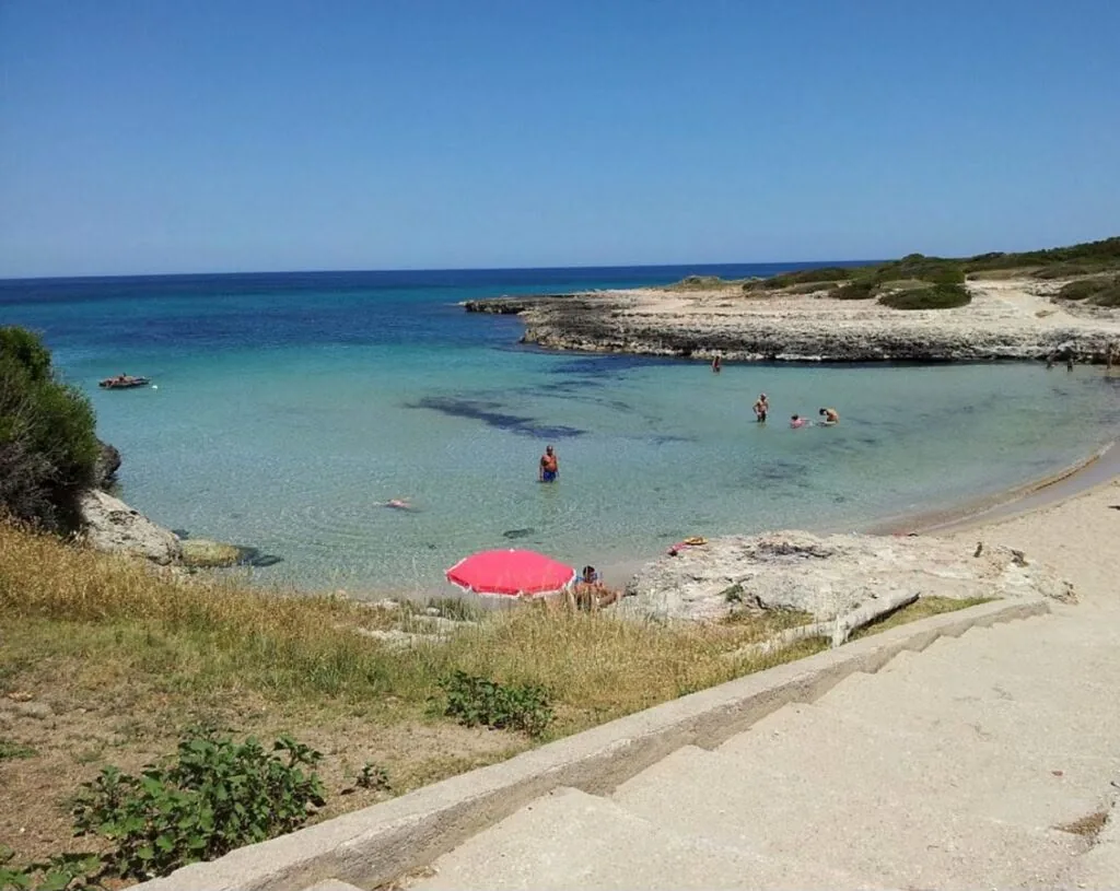 Baia di sabbia con acqua trasparente sulla costa di Ostuni